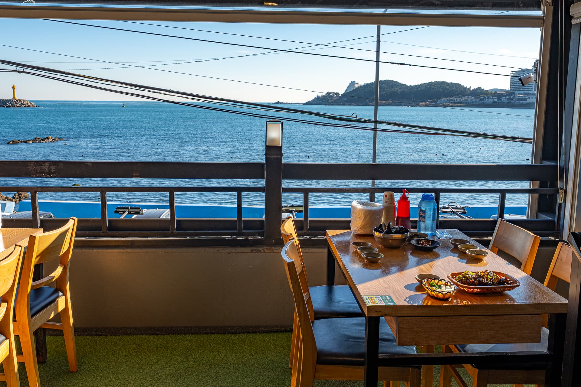 A family dining together at the Jangssi Haenyeo-jip second-floor ocean-view seating