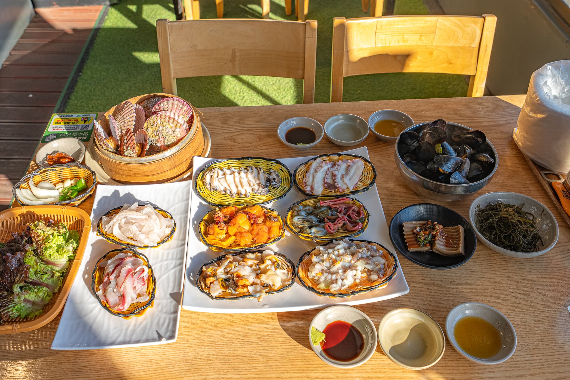 A sashimi table at Jangssi Haenyeo-jip with cheongha: whichever course you pick, the 51-year touch is the same