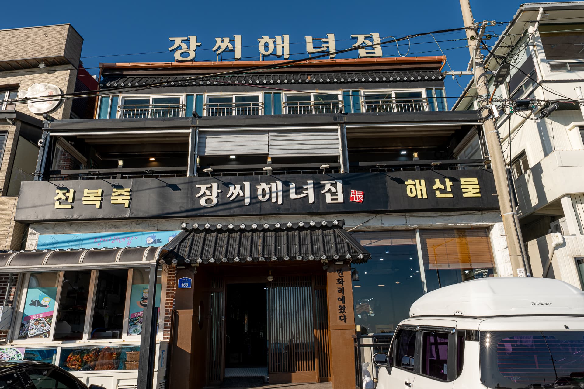 장씨해녀집 연화리 본점 외관 대로변에 위치한 매장과 공영주차장