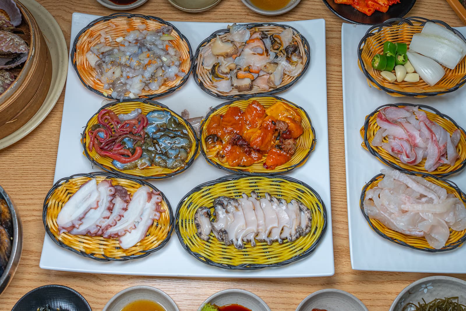 부산 대표 해산물 12선이 한 자리에 차려진 매거진 컷. 광어회·전복·멍게·해삼 등이 한 상에