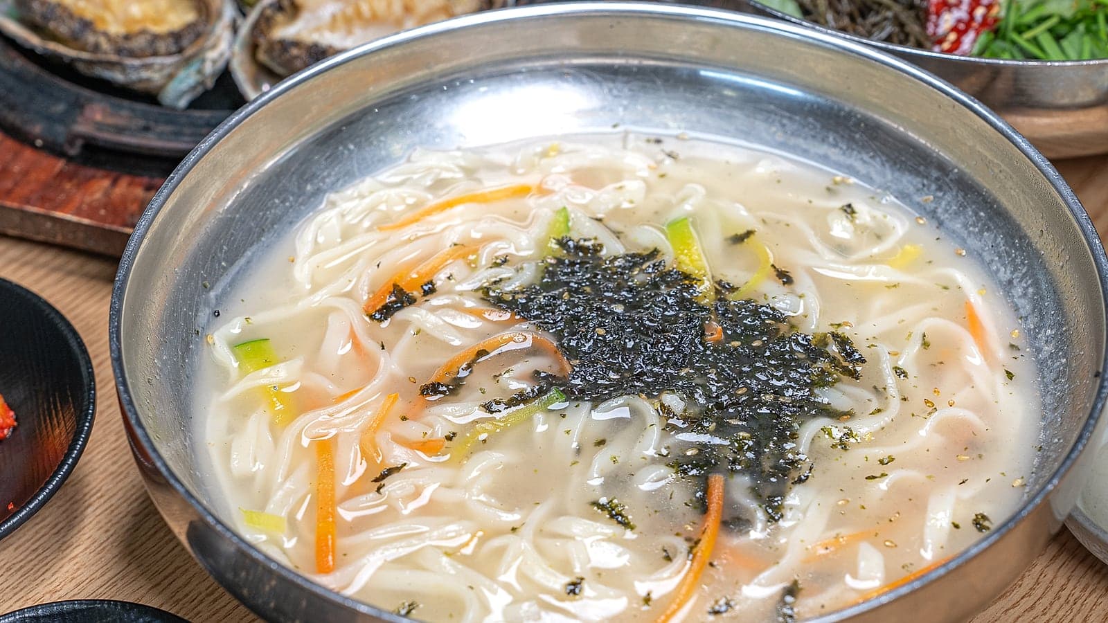 김을 올린 손칼국수 한 그릇, 두툼한 면과 맑은 국물이 담긴 정면 시선