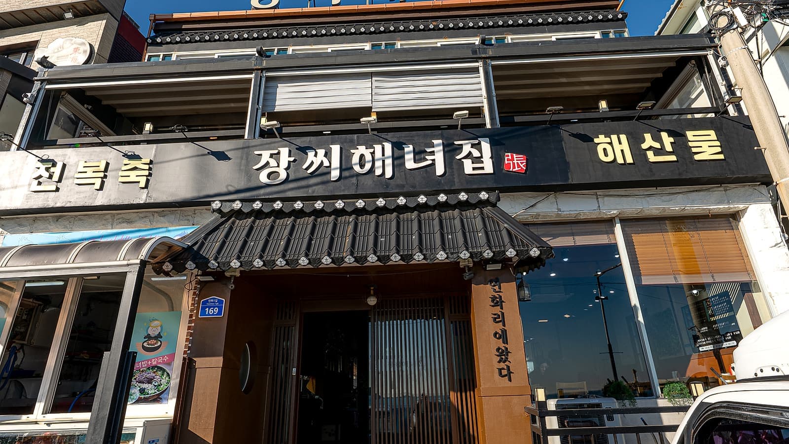 연화리 해녀촌 장씨해녀집 정면 외관, 기와 차양과 간판이 보이는 맑은 낮 시간대 도착 시야